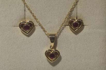 un juego de colgante y pendientes con corazones pequeños en oro amarillo y rubies