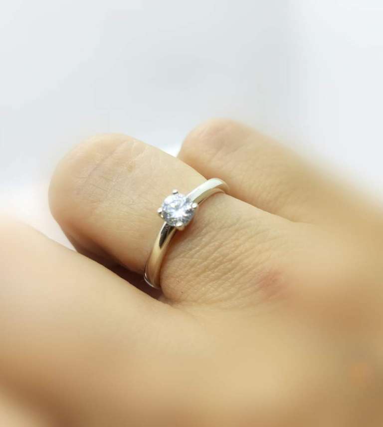 Solitaire engagement ring on a hand